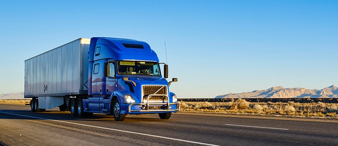 Truck Route news realease banner with blue semi truck driving down highway