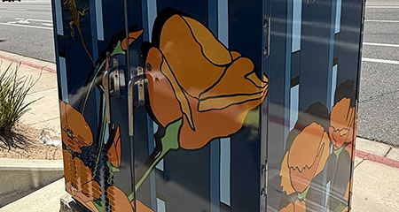Utility box wrap of comic strip containg two humans and their pet dog.