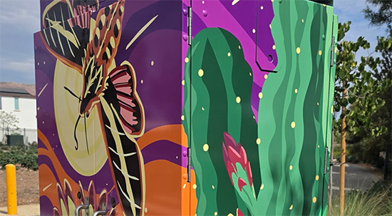 Utility box wrap with large blooming cactus with moths flying around the flowers.